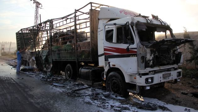 A damaged truck carrying aid is seen on the side of the road in the town of Orum al-Kubra on the western outskirts of the northern Syrian city of Aleppo on September 20, 2016, the morning after a convoy delivering aid was hit by a deadly air strike. The UN said at least 18 trucks in the 31-vehicle convoy were destroyed en route to deliver humanitarian assistance to the hard-to-reach town. / AFP PHOTO / Omar haj kadour