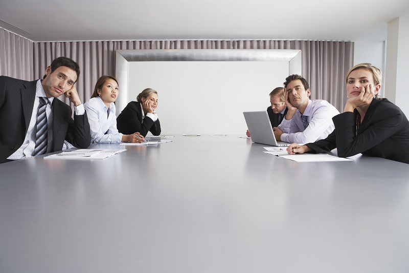 Bored multiethnic business people sitting in conference room