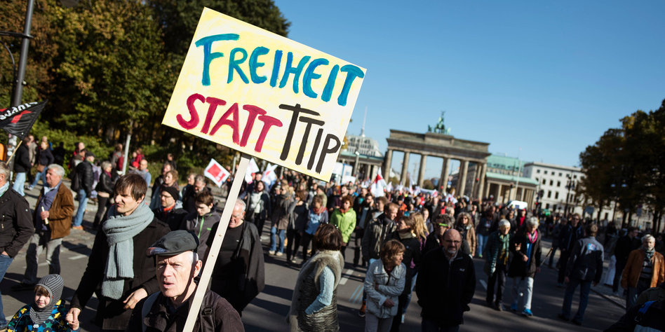 Ein Mann trägt am 10.10.2015 ein Schild mit der Aufschrift "FREIHEIT STATT TTIP" auf einer Demonstration gegen das transatlantische Handelsabkommen TTIP (USA) und Ceta (Kanada) auf der Straße des 17. Juni in Berlin. Organisiert wird die Protestaktion unter anderem von Umwelt-, Sozial-, Kultur- und Verbraucherverbänden, darunter der BUND und der Deutsche Gewerkschaftsbund (DGB). Foto: Gregor Fischer/dpa +++(c) dpa - Bildfunk+++